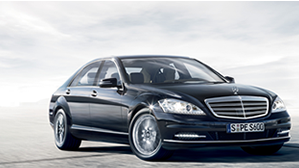 Black Mercedes-Benz S-Class driving on the sand.